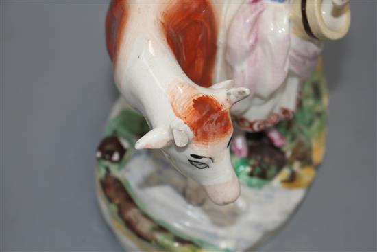 A Staffordshire pottery group of a milkmaid and cow, L. 21cm